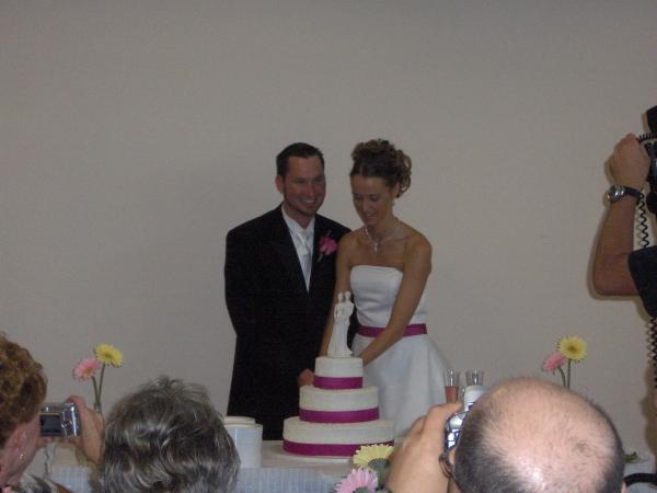 Bryce the groom and Emily the Bride cutting the cake